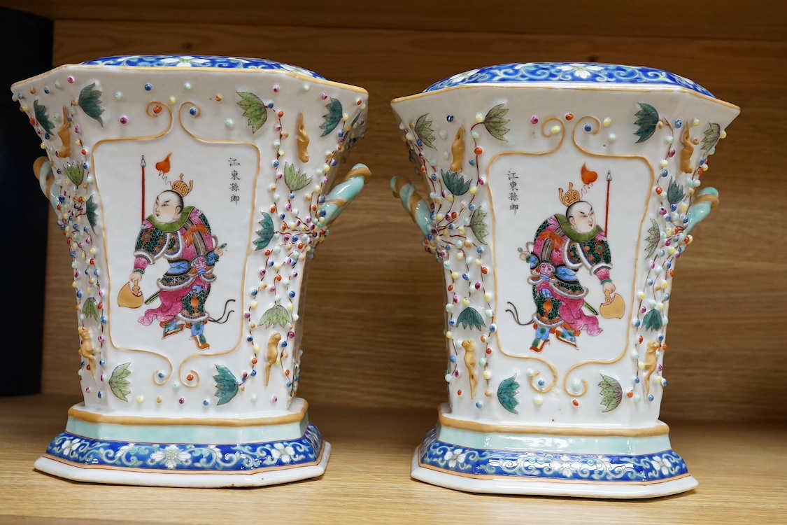 A pair of Chinese famille rose bough pots, painted with figures and calligraphy, 24cm high. Condition - one cover damaged